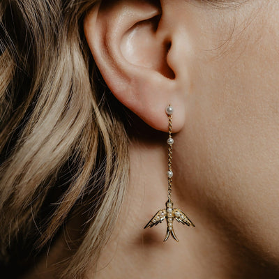 A perfect love token piece of jewelry! Romantic and very symbolic these antique revival drop earrings are handmade by our goldsmiths. Made of solid 10k yellow gold, these beautiful Victorian style swallow earrings are set with natural pearls.