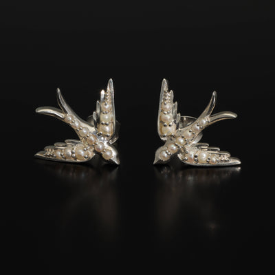 A perfect love token piece of jewelry! Romantic and very symbolic these antique revival studs are handmade by our goldsmiths. Made of solid 14k yellow gold or sterling silver, these beautiful antique style swallow earrings are set with natural pearls.