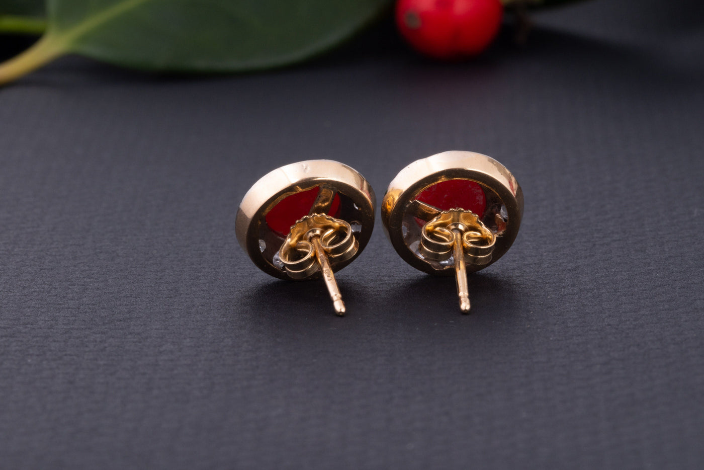 A statement pair of vintage mid-century earrings made of solid 18 kt gold. These head-turning earrings have a classic geometric design and are set with two large red coral cabochons.  The coral cabochons measure 0.35 inch in diameter each and are in a lovely vintage condition with no surface wear.