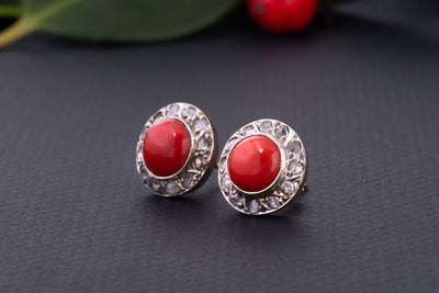 A statement pair of vintage mid-century earrings made of solid 18 kt gold. These head-turning earrings have a classic geometric design and are set with two large red coral cabochons.  The coral cabochons measure 0.35 inch in diameter each and are in a lovely vintage condition with no surface wear.