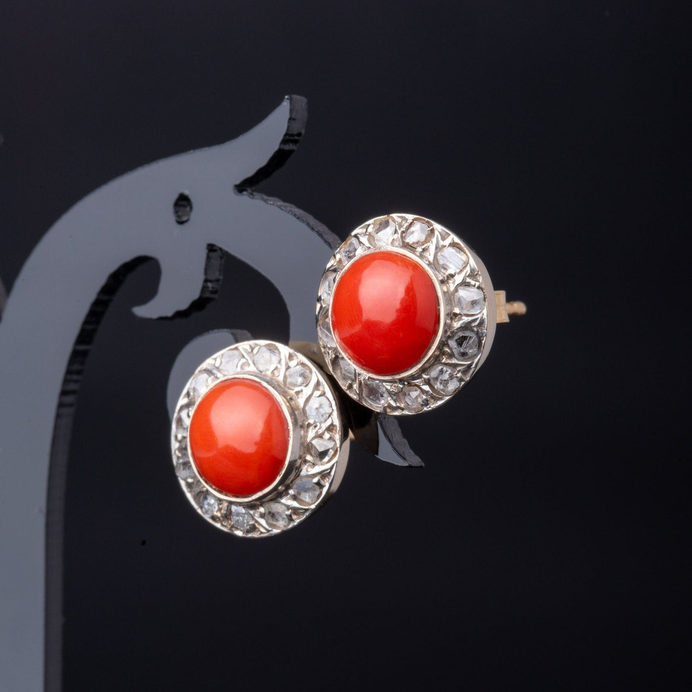 A statement pair of vintage mid-century earrings made of solid 18 kt gold. These head-turning earrings have a classic geometric design and are set with two large red coral cabochons.  The coral cabochons measure 0.35 inch in diameter each and are in a lovely vintage condition with no surface wear.