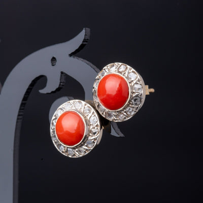 A statement pair of vintage mid-century earrings made of solid 18 kt gold. These head-turning earrings have a classic geometric design and are set with two large red coral cabochons.  The coral cabochons measure 0.35 inch in diameter each and are in a lovely vintage condition with no surface wear.