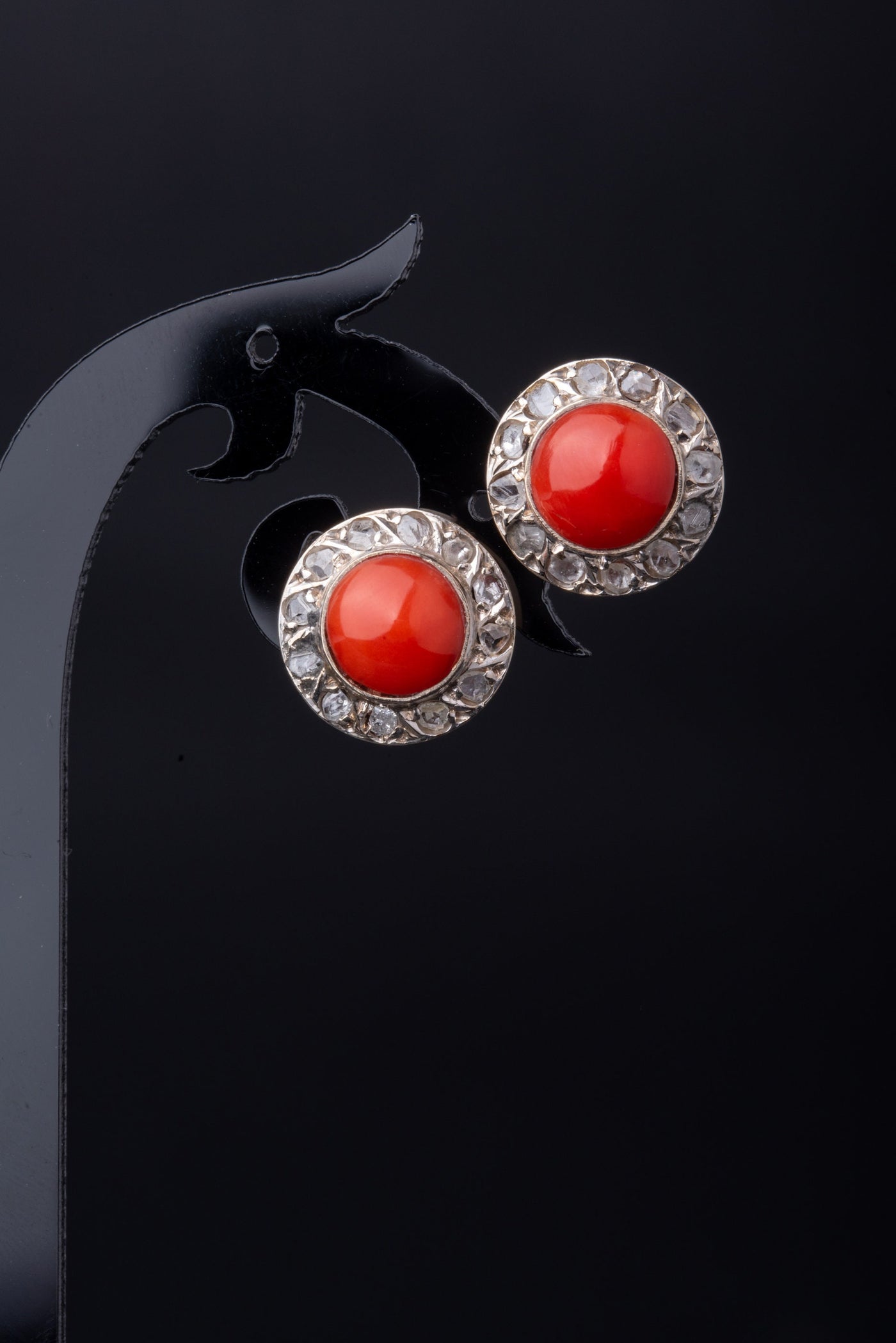 A statement pair of vintage mid-century earrings made of solid 18 kt gold. These head-turning earrings have a classic geometric design and are set with two large red coral cabochons.  The coral cabochons measure 0.35 inch in diameter each and are in a lovely vintage condition with no surface wear.