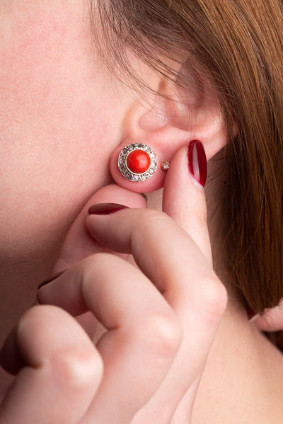 A statement pair of vintage mid-century earrings made of solid 18 kt gold. These head-turning earrings have a classic geometric design and are set with two large red coral cabochons.  The coral cabochons measure 0.35 inch in diameter each and are in a lovely vintage condition with no surface wear.