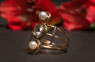 A very unusual Victorian revival three-stones ring, featuring two snow-white pearls and a chunky oval rose cut diamond of circa 0.8 ct.