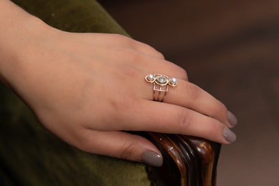 A very unusual Victorian revival three-stones ring, featuring two snow-white pearls and a chunky oval rose cut diamond of circa 0.8 ct.